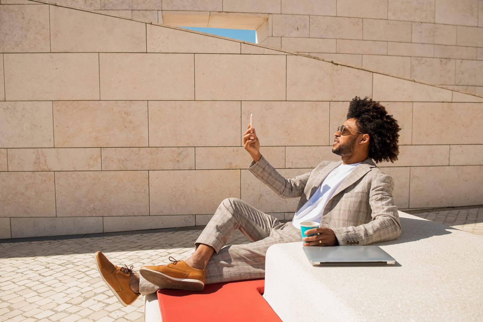 Pleased African American man video calling in open air